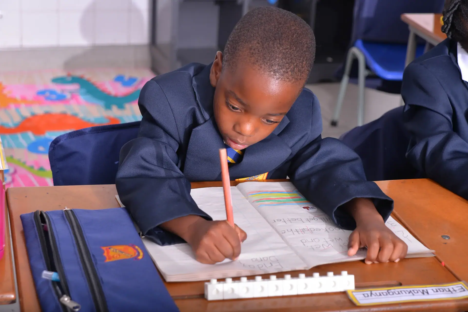 A young pupil concentrating on his handwriting
