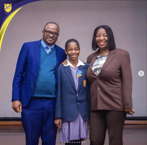 A pupil with her parents at the awards assembly